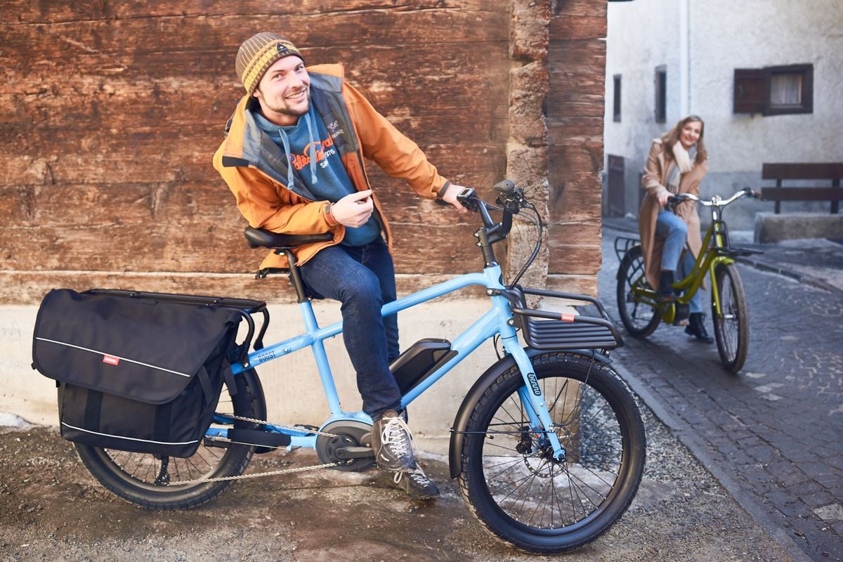 Two riders enjoying their benno e-bikes in an urban setting.